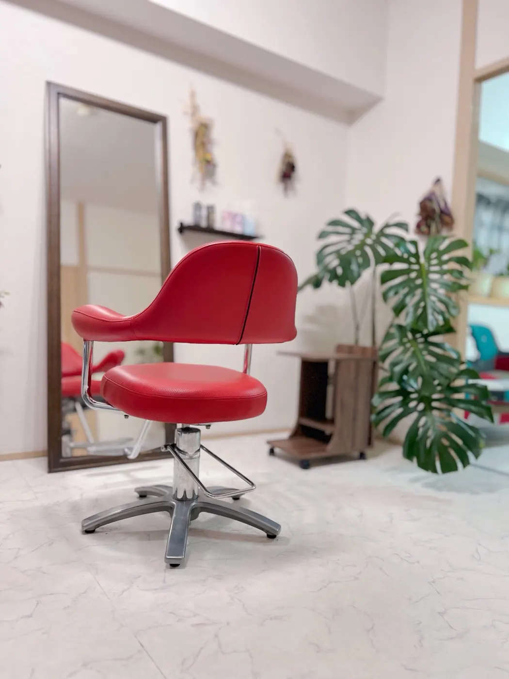 赤いチェアと観葉植物があるHair Salon Valerieの個室
